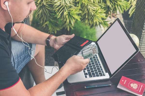 A man is searching on his laptop where to keep an emergency fund