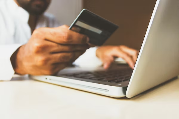 a man with a laptop checking his credit card